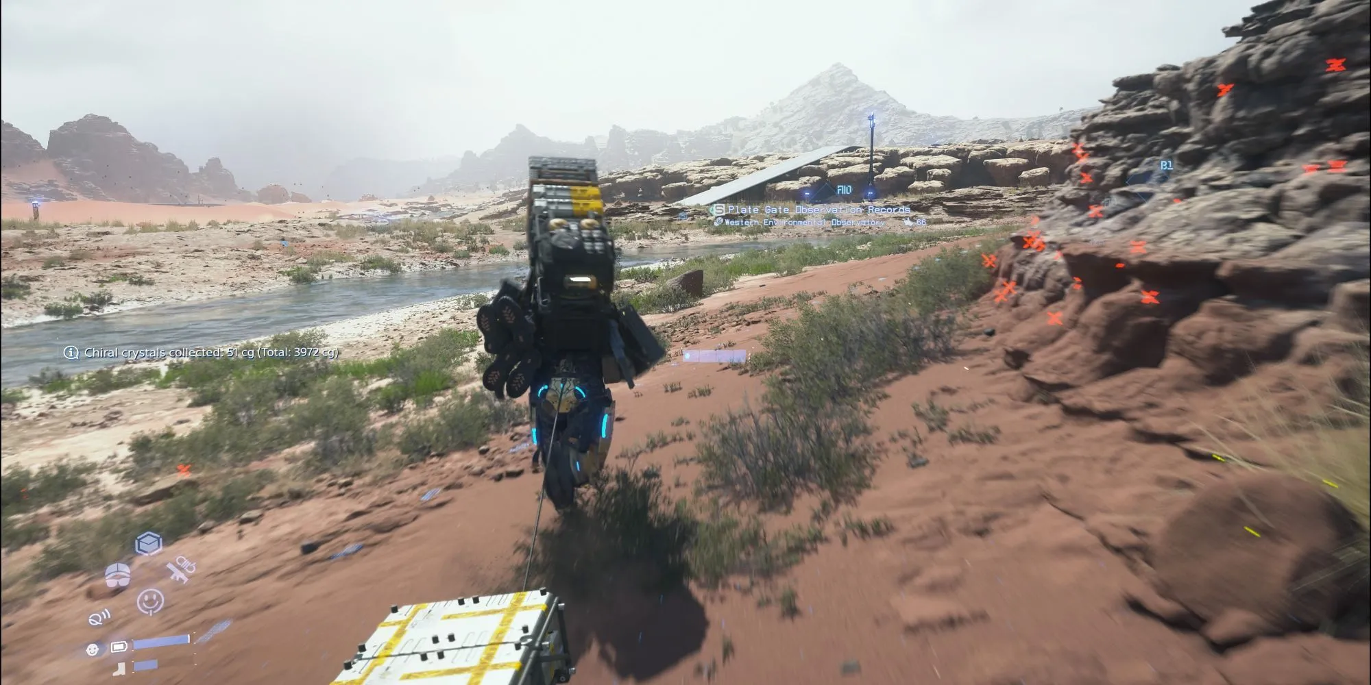 Sam Bridges đang đi bộ qua một cảnh quan tự nhiên hiểm trở, có thể ở Australia, trong Death Stranding 2.