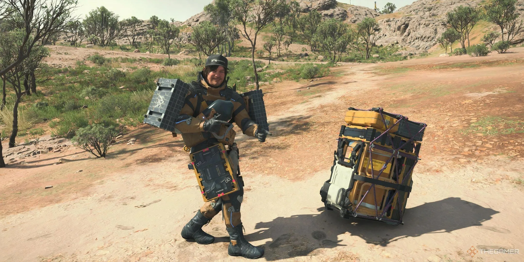 Sam Bridges đứng cạnh hàng hóa được buộc chặt bằng sợi Strand trong Death Stranding 2, minh họa khả năng vận chuyển